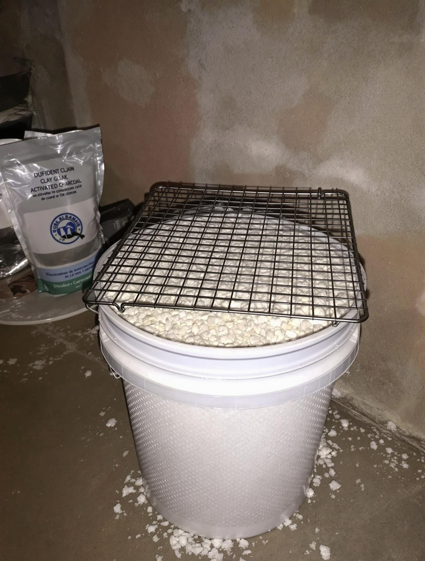 Absorbeur d’humidité maison : seau percé rempli de sel gemme, argile et charbon actif.