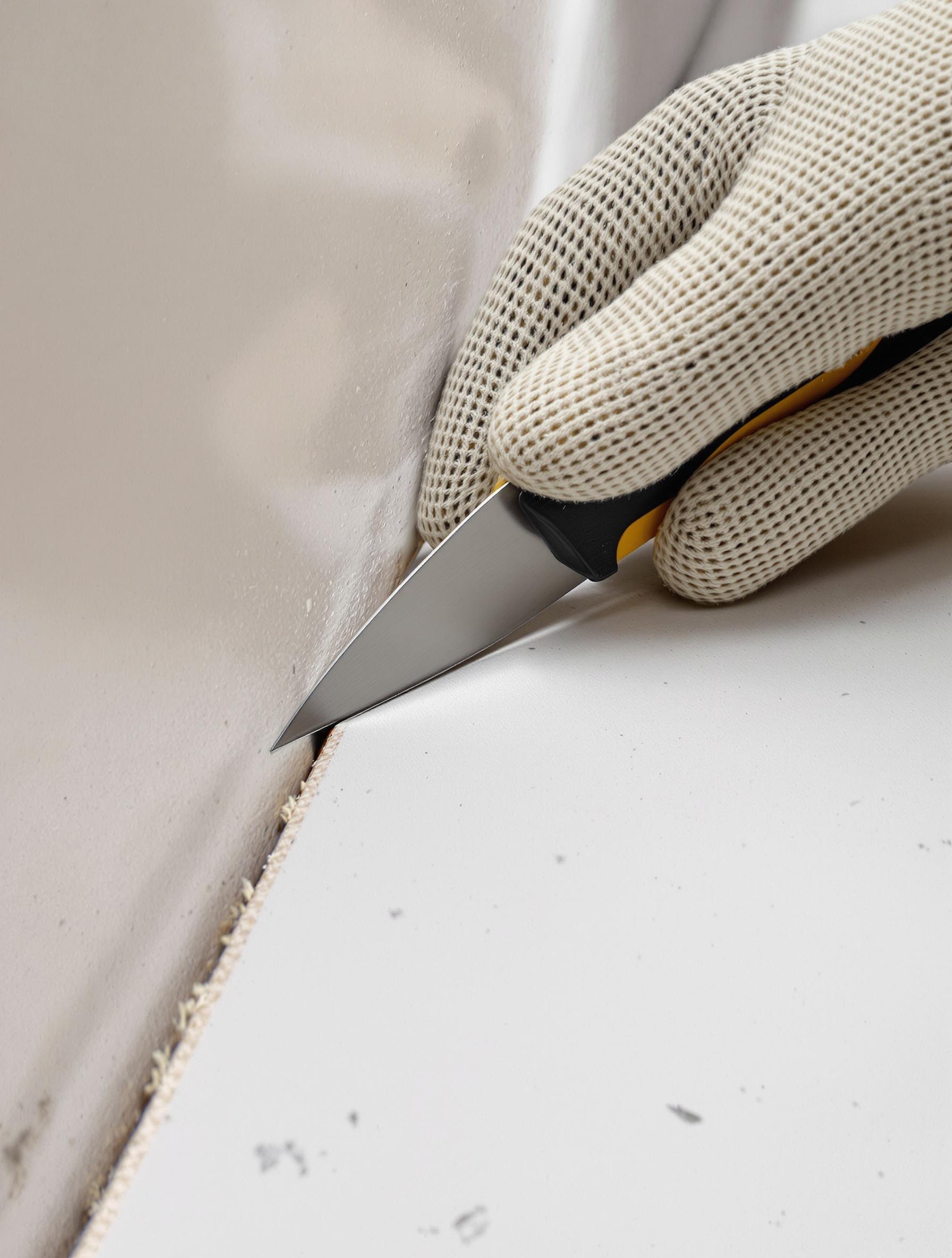 Découpe droite au cutter sur une plaque de plâtre posée