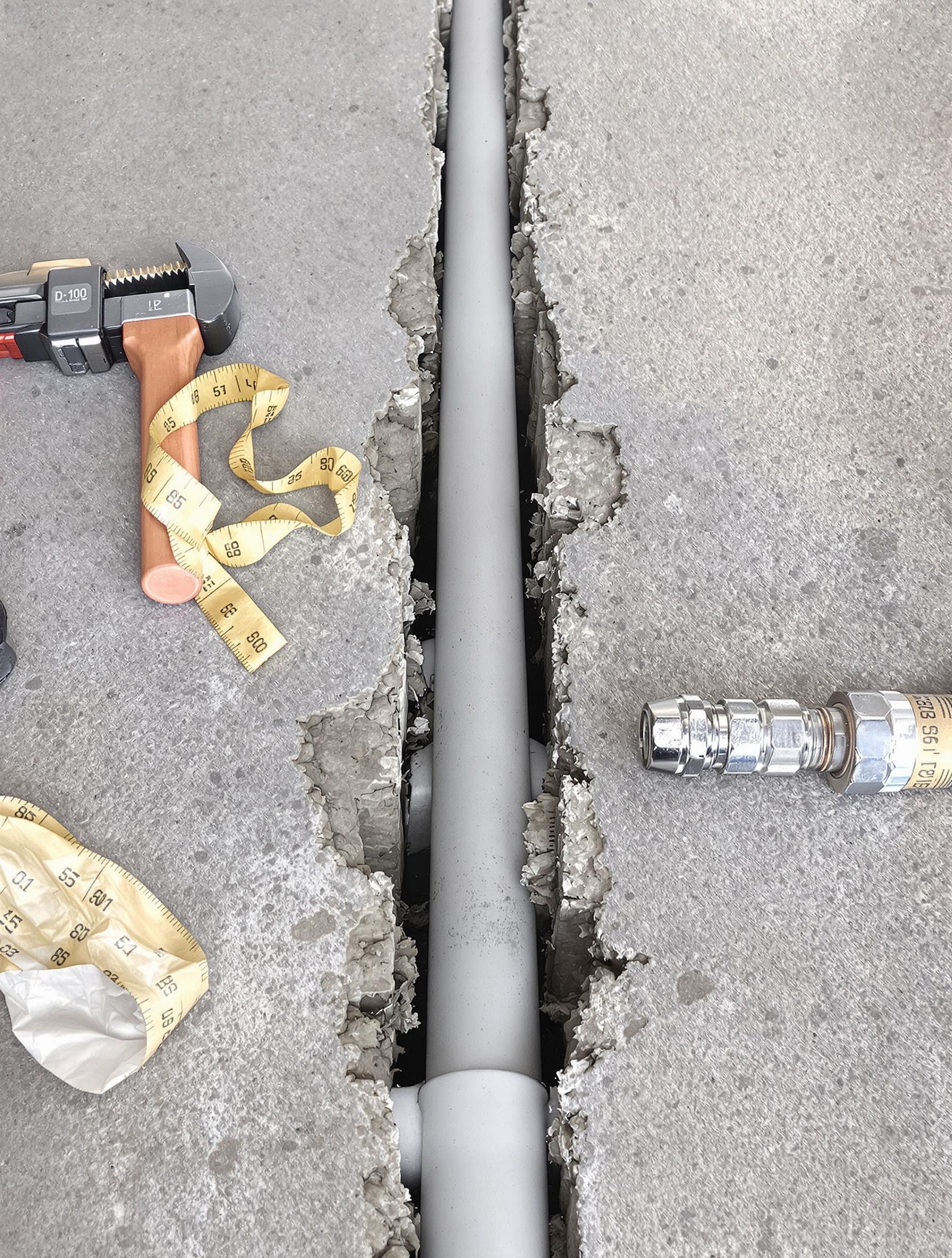 Tuyau PVC D100 installé dans une chape en béton sur un chantier de plomberie.