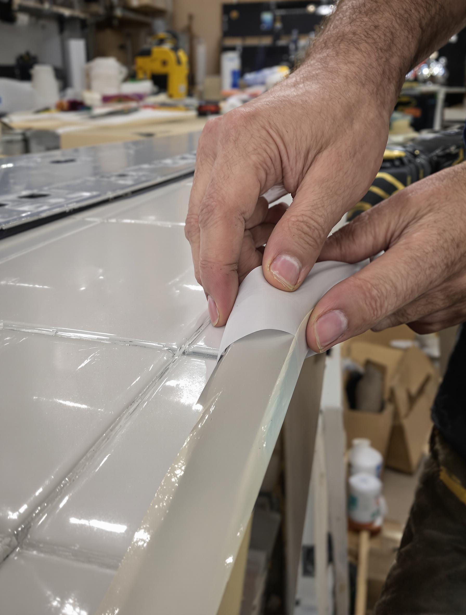 Utilisation de ruban adhésif pour une découpe propre de plinthes en carrelage.