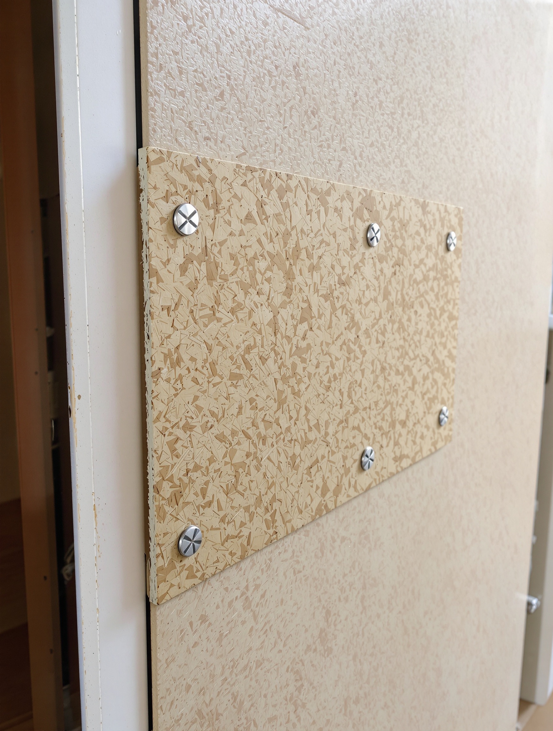 Porte barricadée par planche OSB vissée – protection anti-squat maison